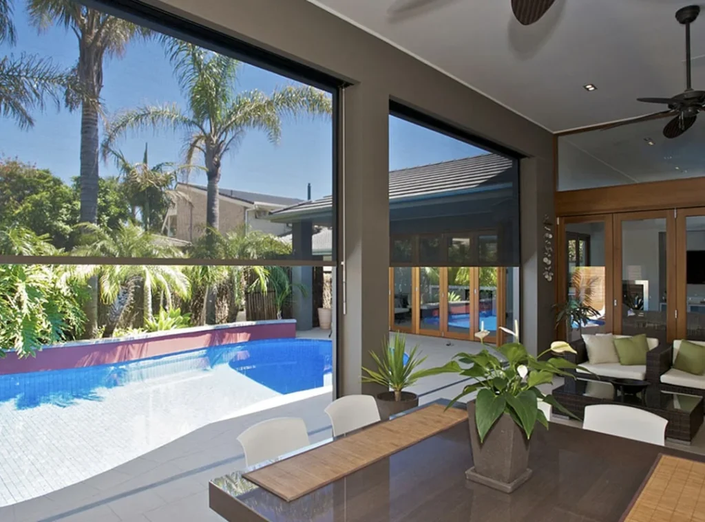 Spacious modern room overlooking a backyard pool.