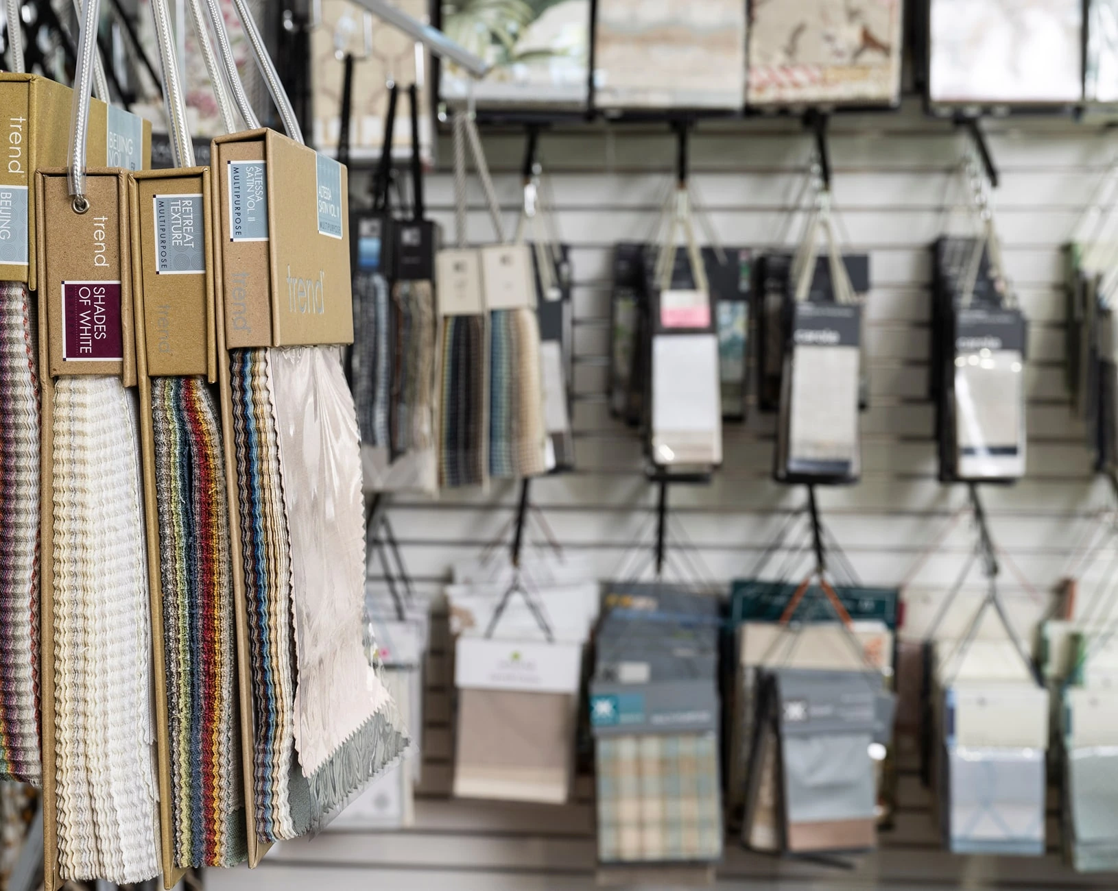 Fabric swatches hanging on a store display wall.