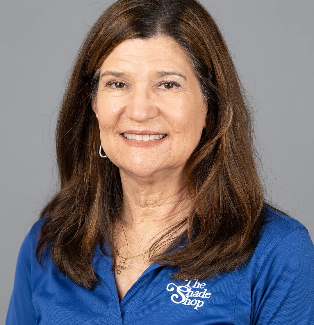 Smiling woman in blue shirt with logo.