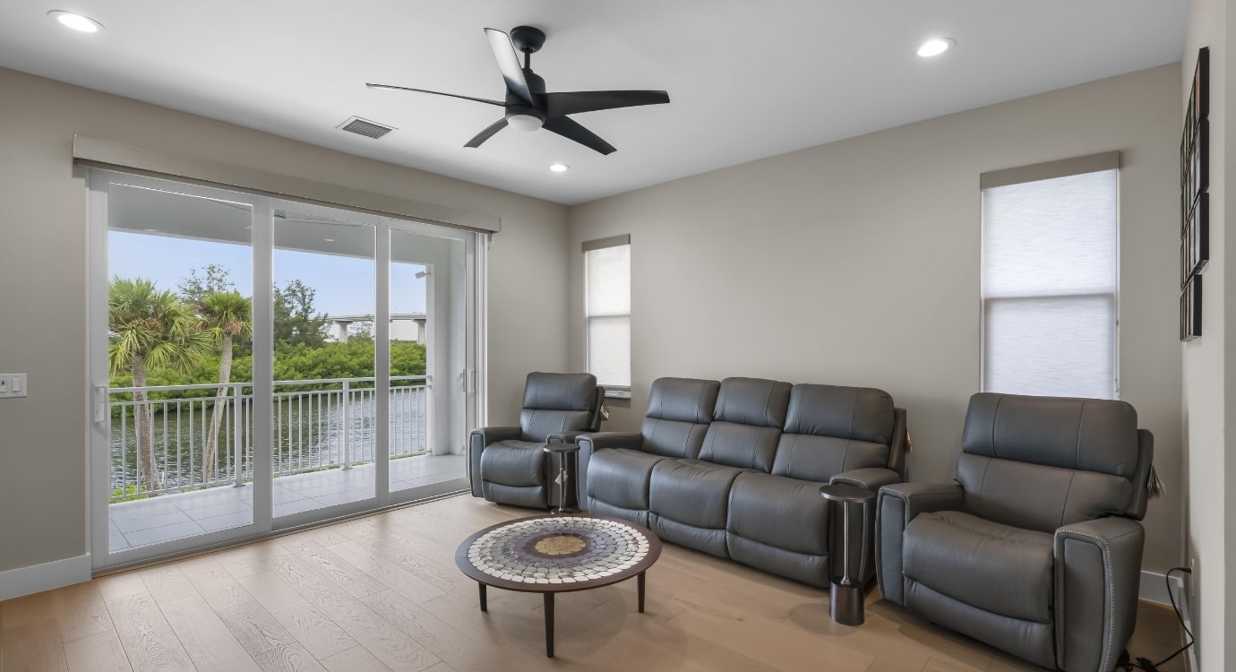 Modern living room with leather recliners and lake view.