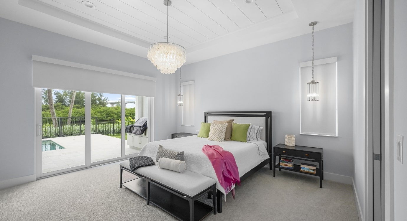 Modern bedroom with large windows and outdoor view.