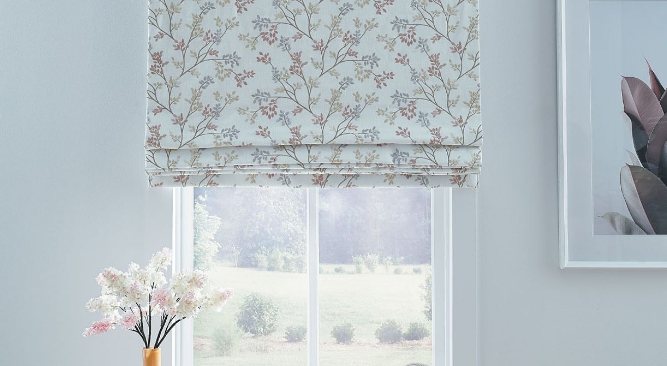 Window with floral Roman shades and vase